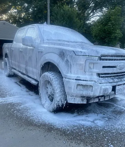 Ford F-150 covered in white foam during detailing