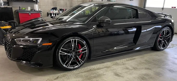 SUV covered in white foam in garage during detailing